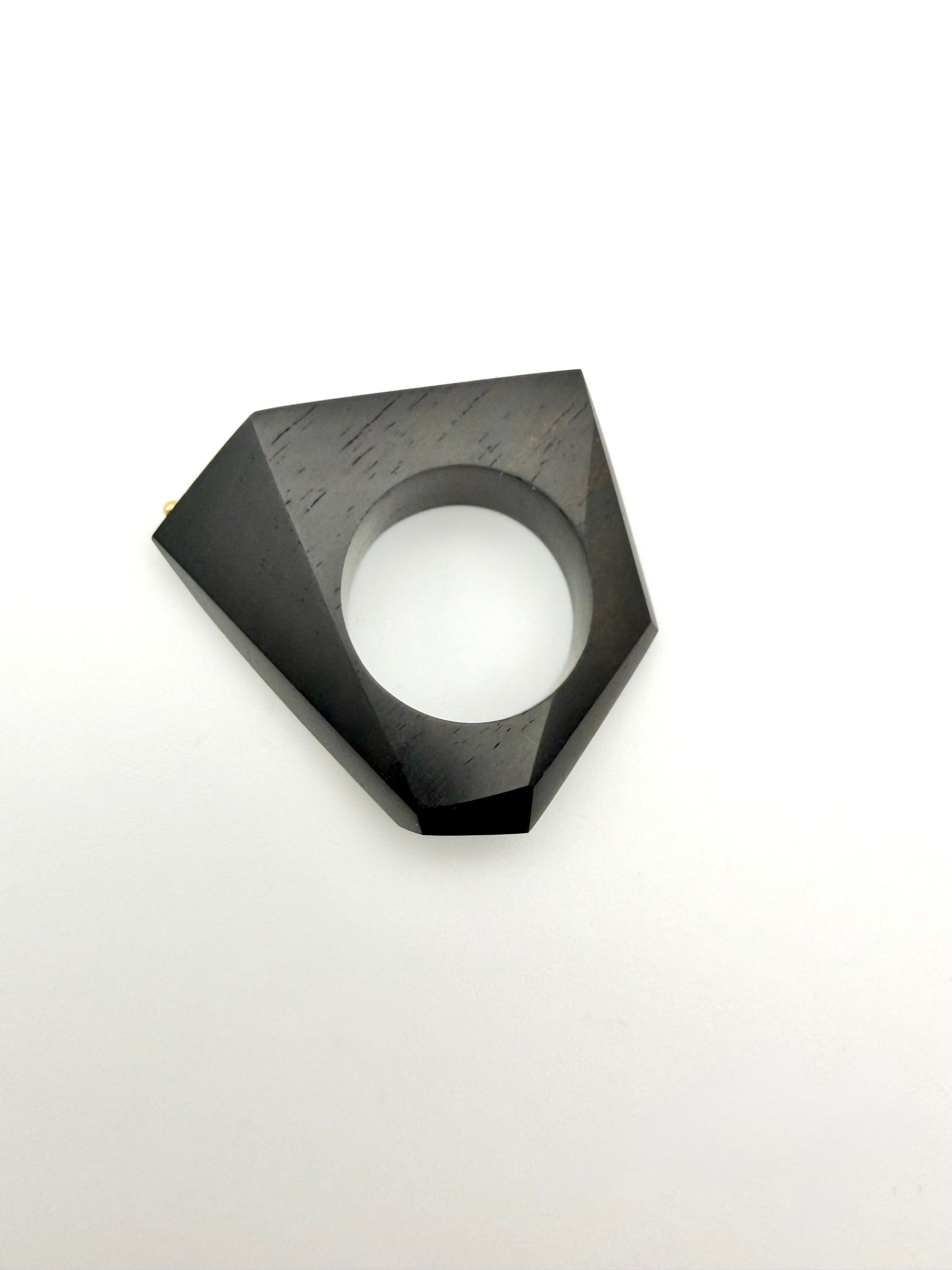 Black geometric Ring on its side on a white background