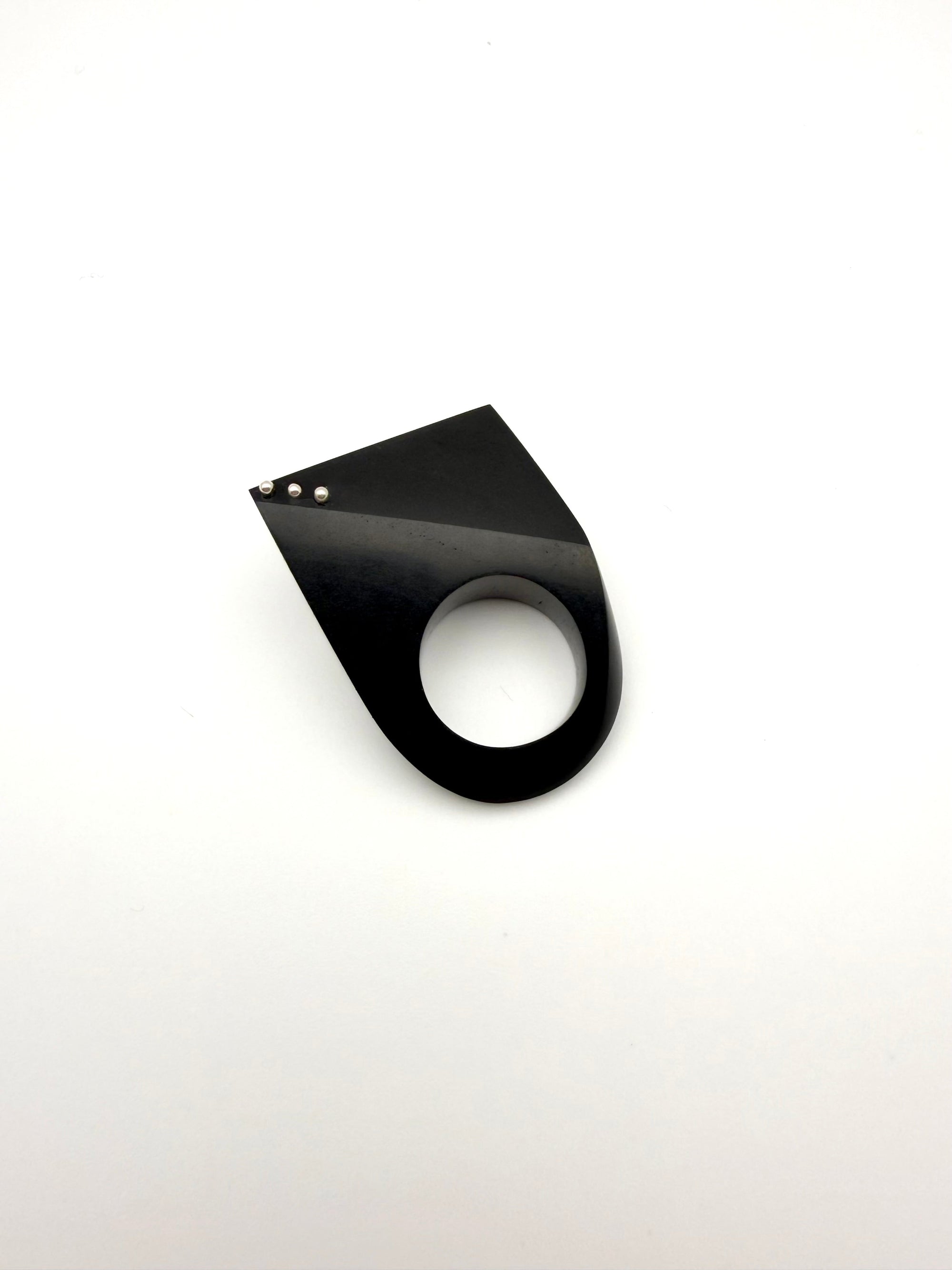 Black geometric wood ring with silver details on a white background