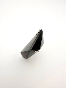 Black geometric wood ring with silver details on a white background