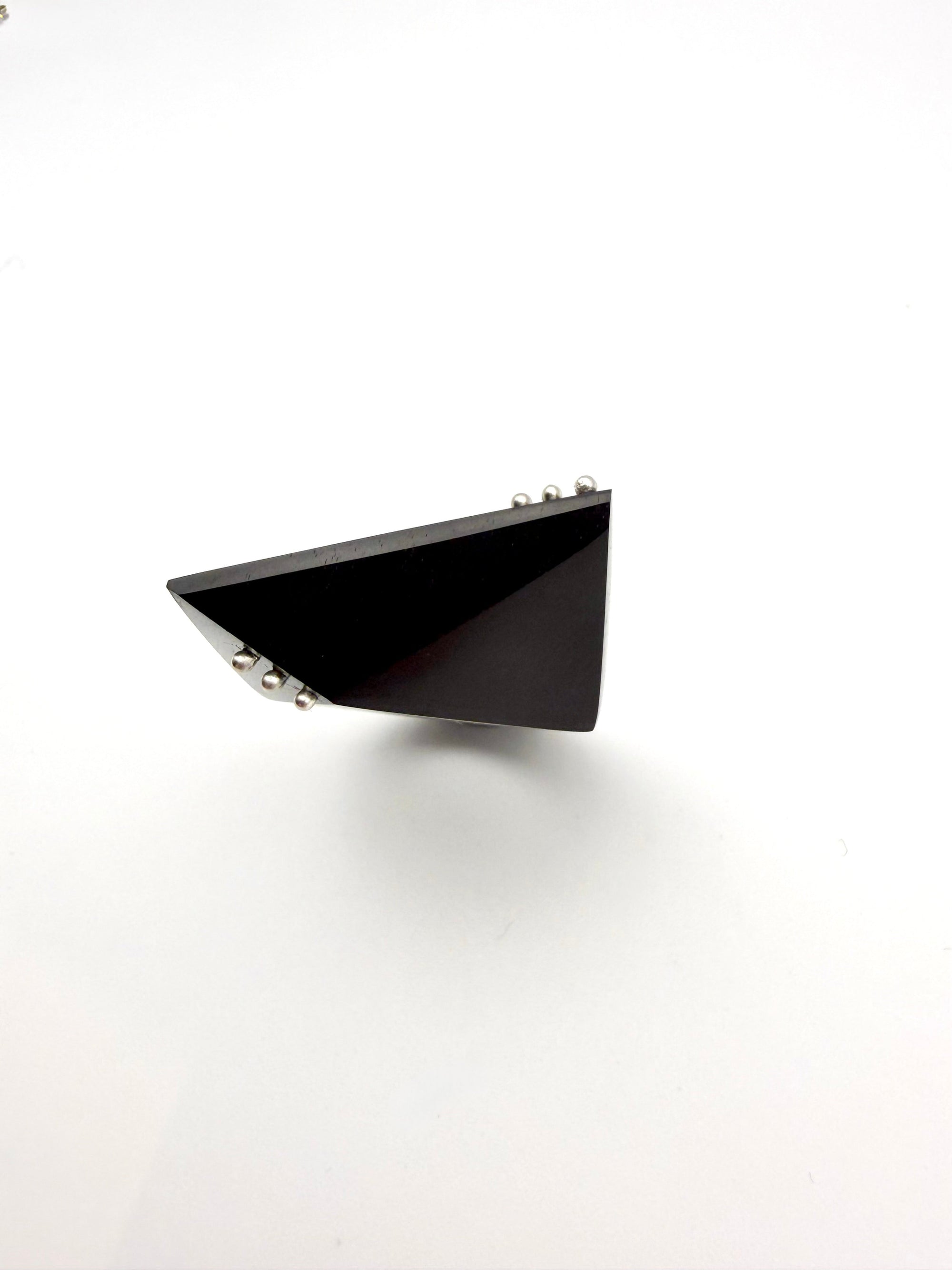 Black triangular ring shot from above on a white background