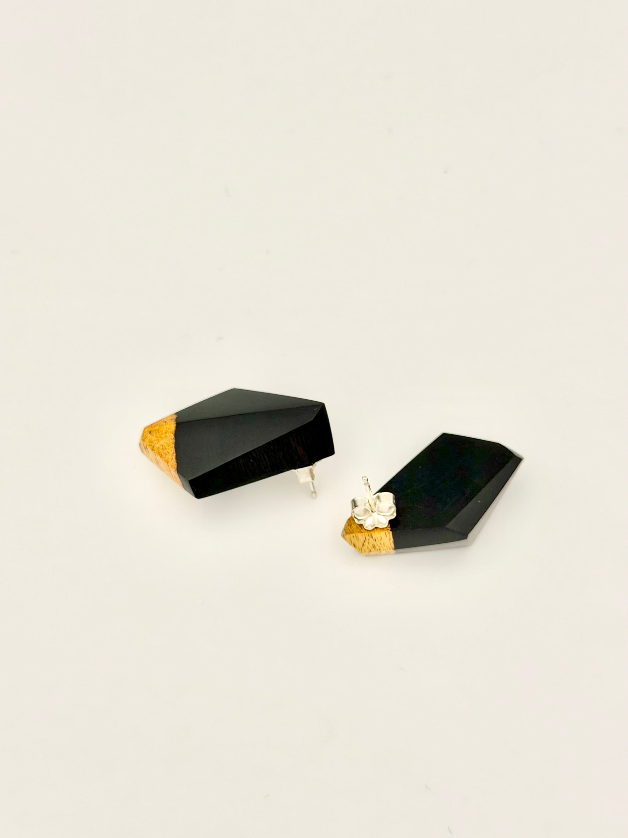 Black wood geometric earrings with sap wood accents on a white background