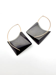 Pair of black square earrings with gold hoop accents on a white background