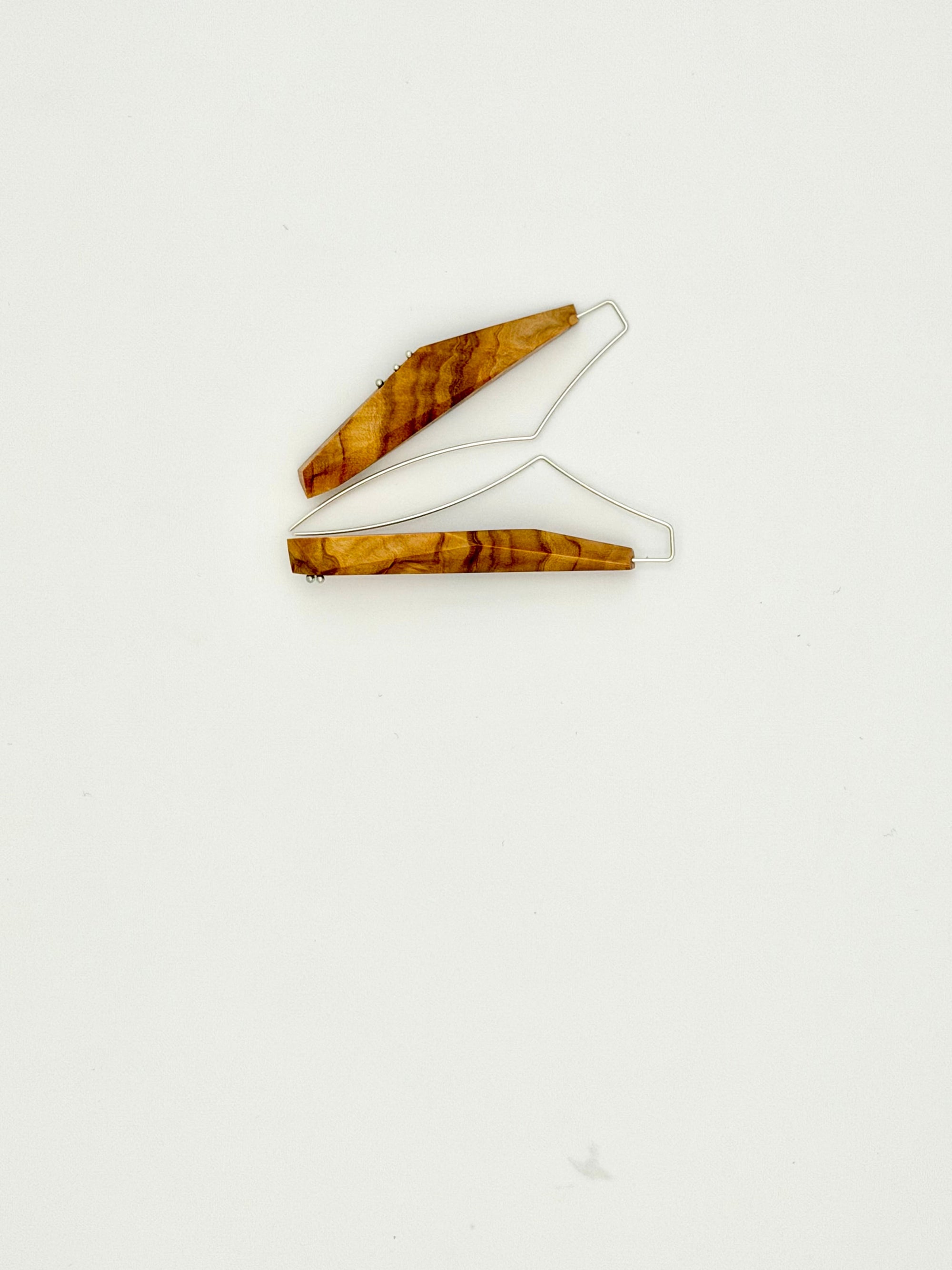 Olivewood asymmetric long narrow earrings with silver details on white background. 