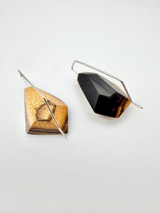 Two geometric earrings on a light gray background