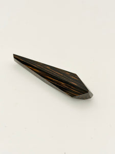 Black and brown geometric wood brooch on white background. 