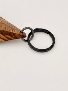 Wooden keychain with black titanium ring on white background