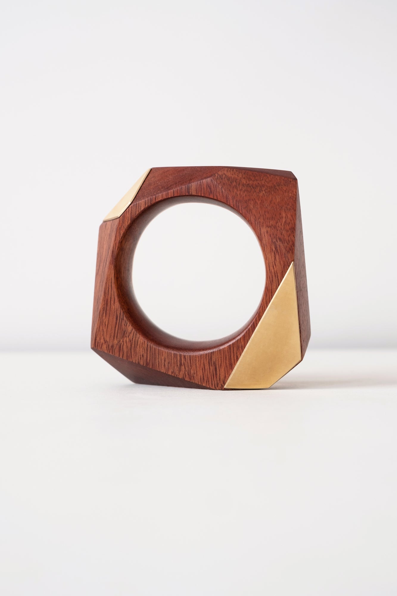 Wooden and Brass geometric object on a white background