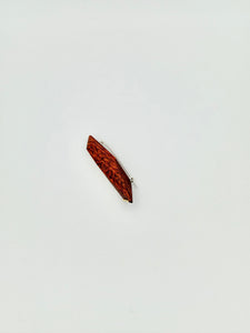 side view of Red geometric wood brooch with 3 dot gold details on white background. 