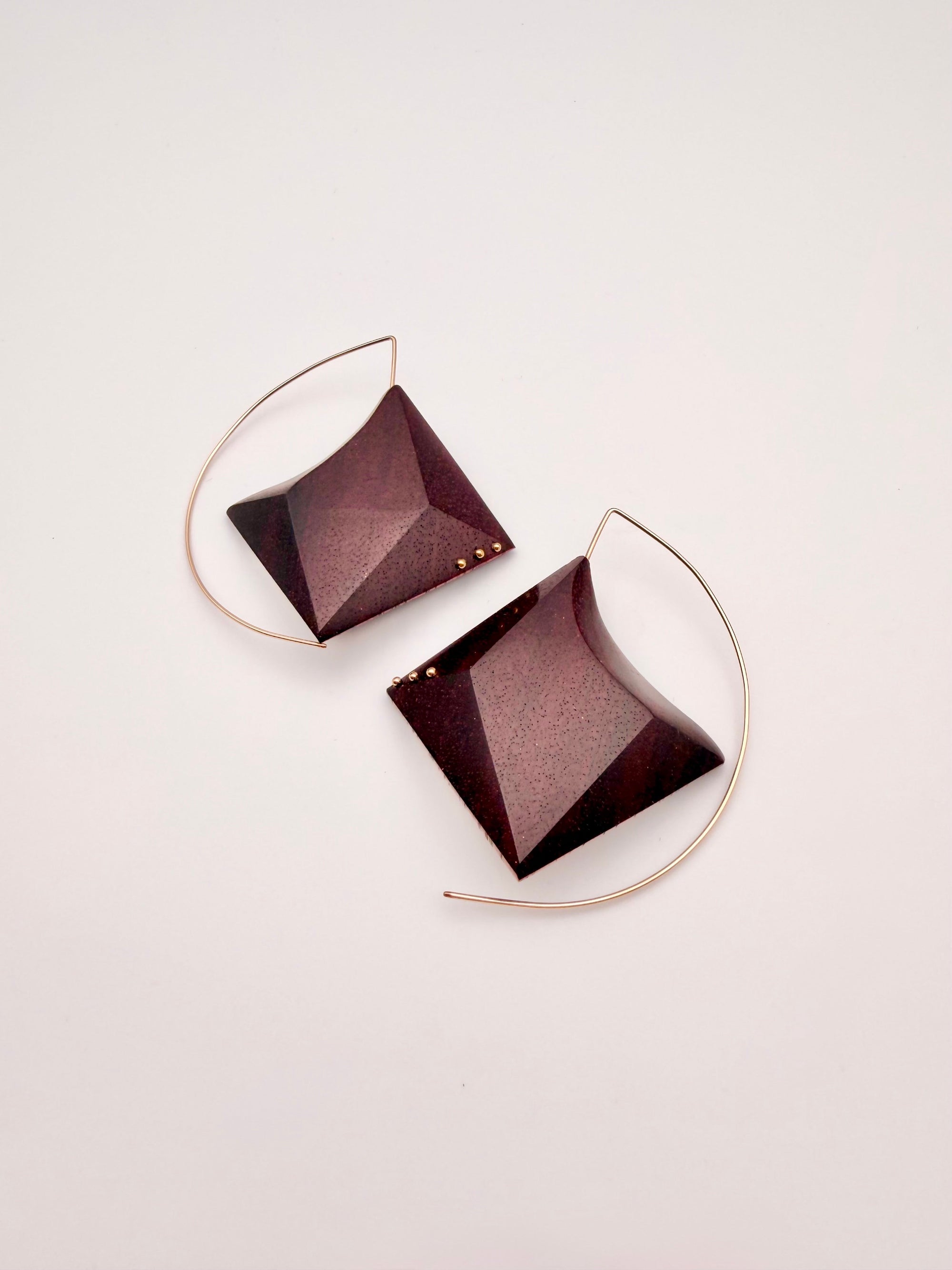 Deep red wood geometric earrings with Gold Filled Details and ear wires on a light background. 