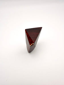 Triangular wooden object with gold accents on a white background