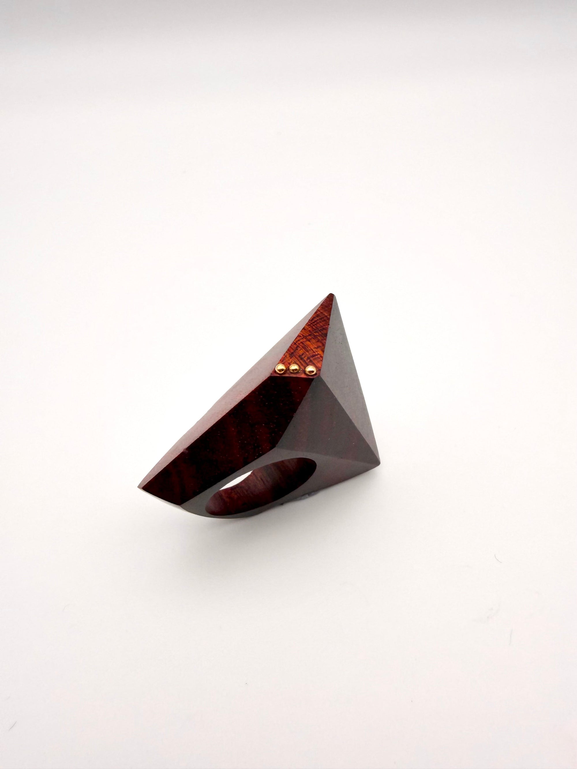 Triangular wooden object with a glossy finish on a white background