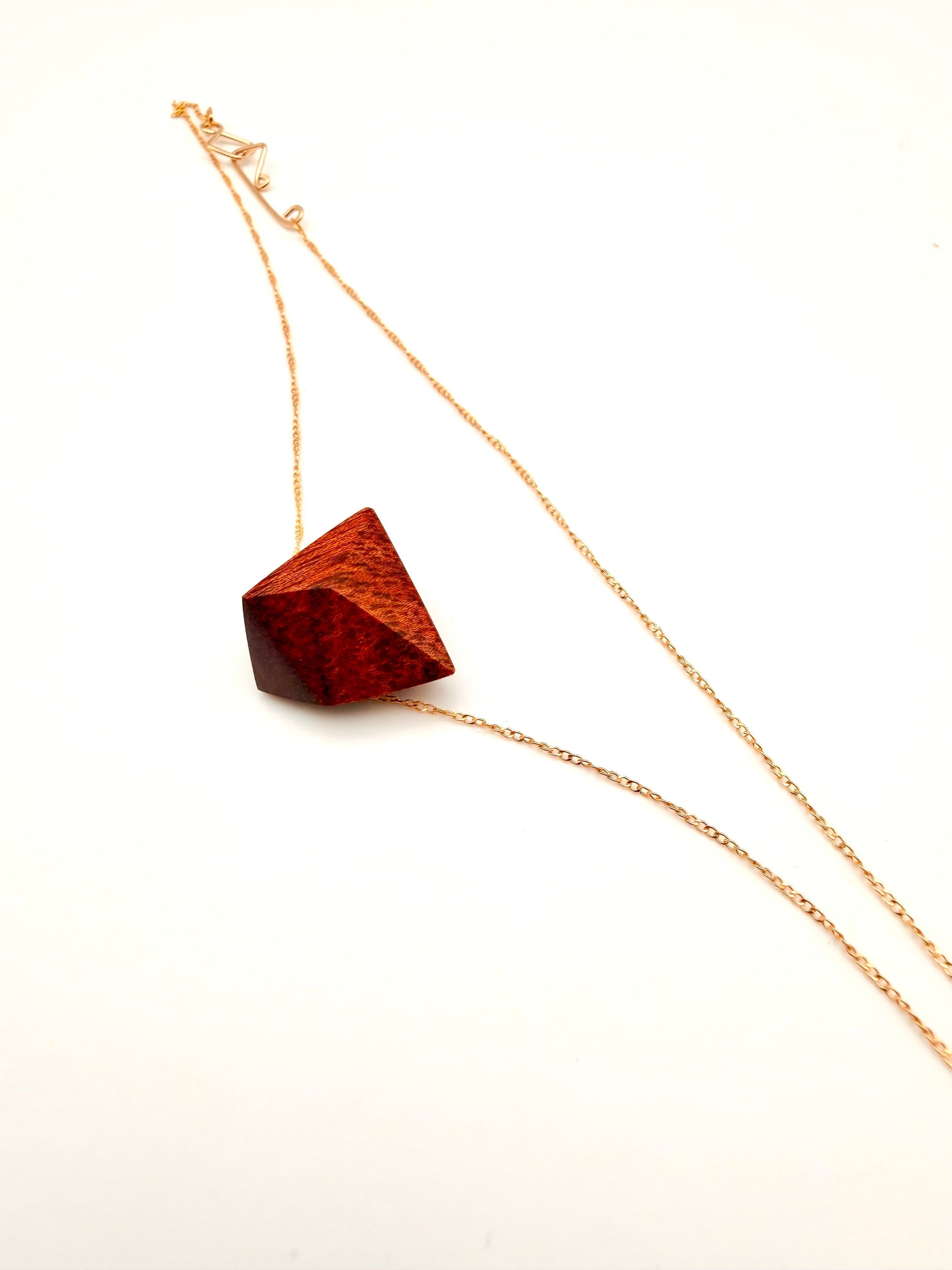 Necklace with a burgundy/red wood geometric pendant on a white background