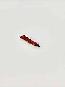 Red geometric wood brooch with 3 dot gold details on white background. 