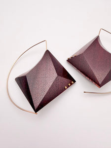 Geometric dark red wood earrings with a gold hoop and 3 dot detail on each earring on a light gray background