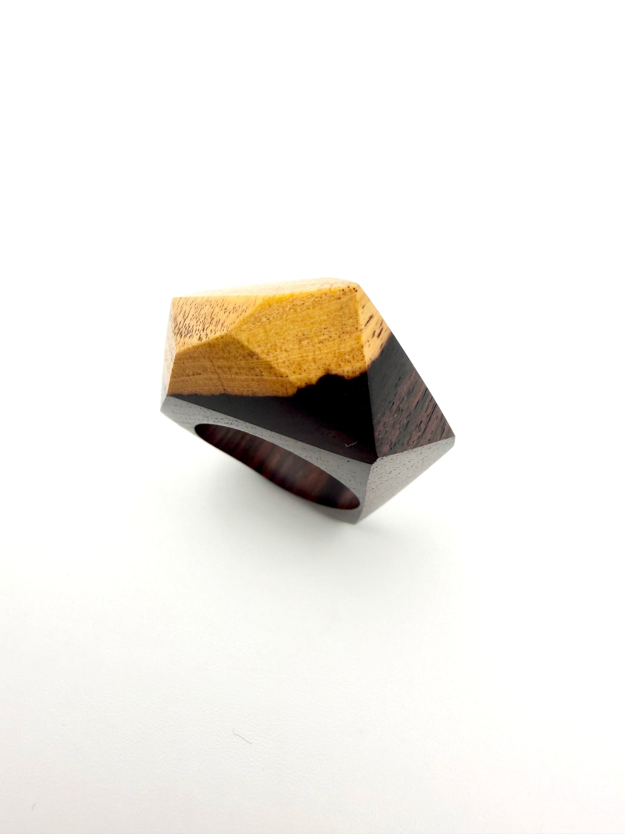 Geometric ring with gold and brown design on a white background