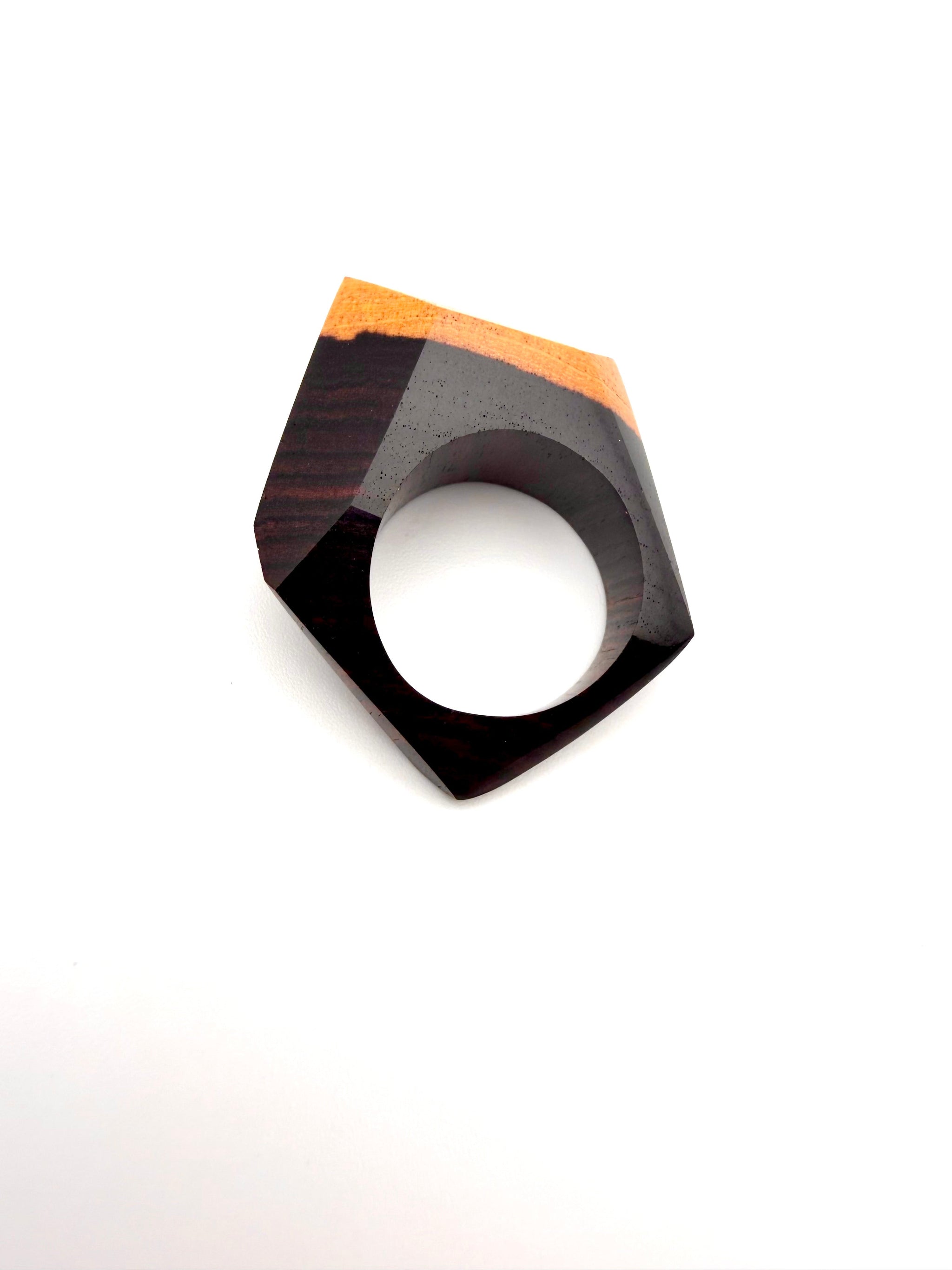 Geometric wooden ring with brown and blond grain design on a white background