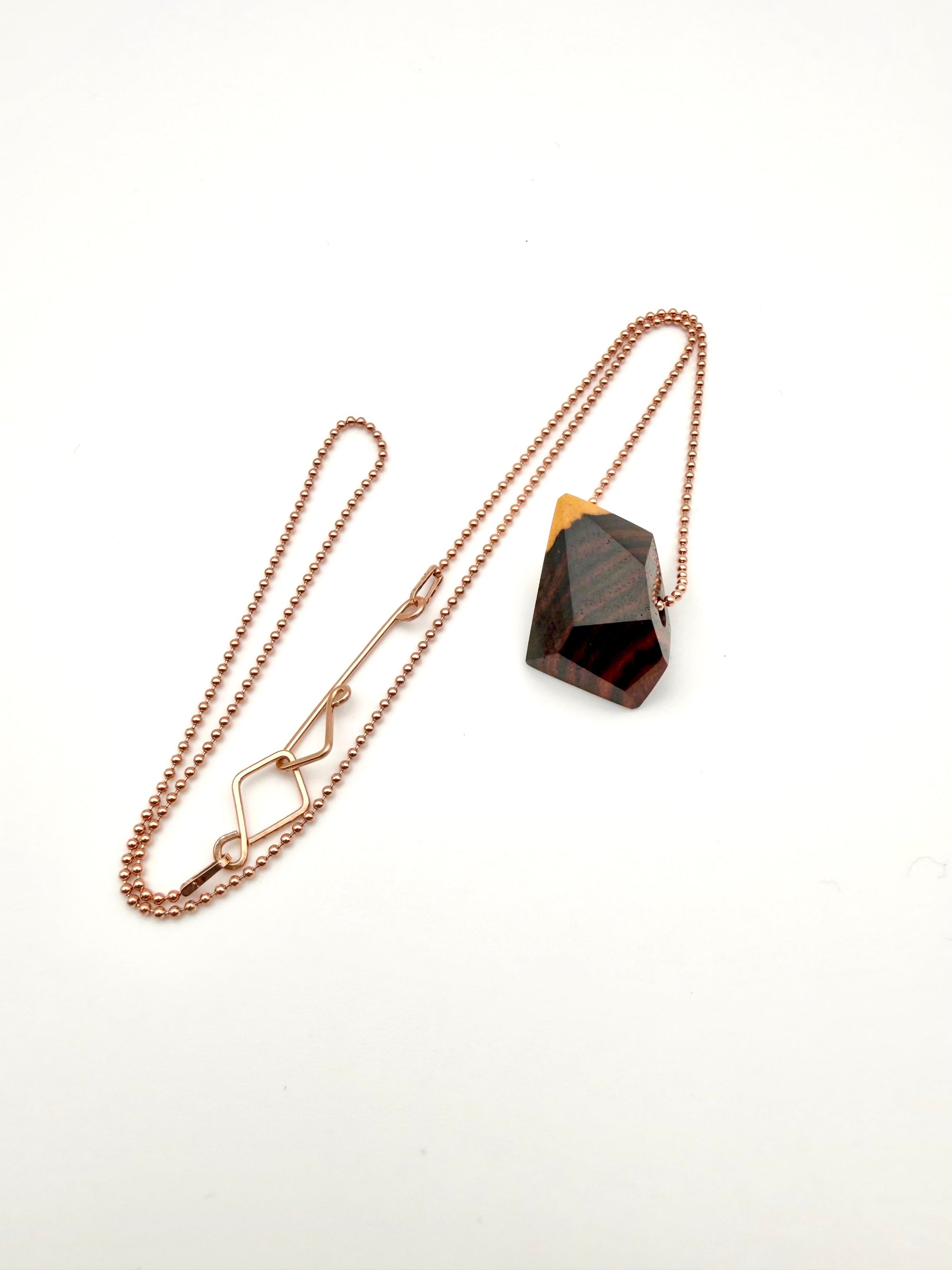 Necklace with a geometric wood pendant on a bead chain with custom clasp on a white background