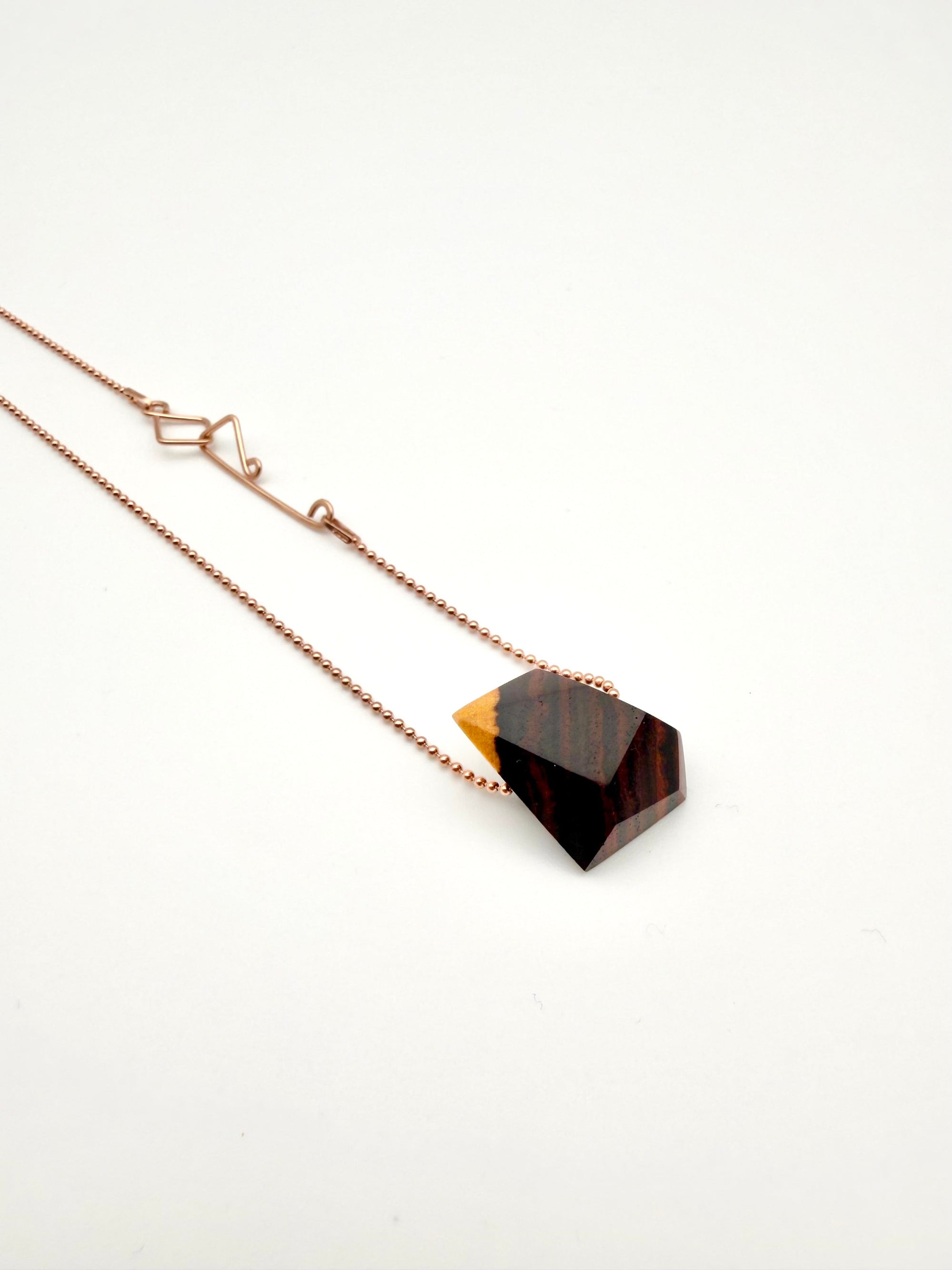 Necklace with a geometric wood pendant with Rose gold ball chain and custom clasp on a white background