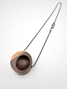 Wooden pendant with chain on a white background