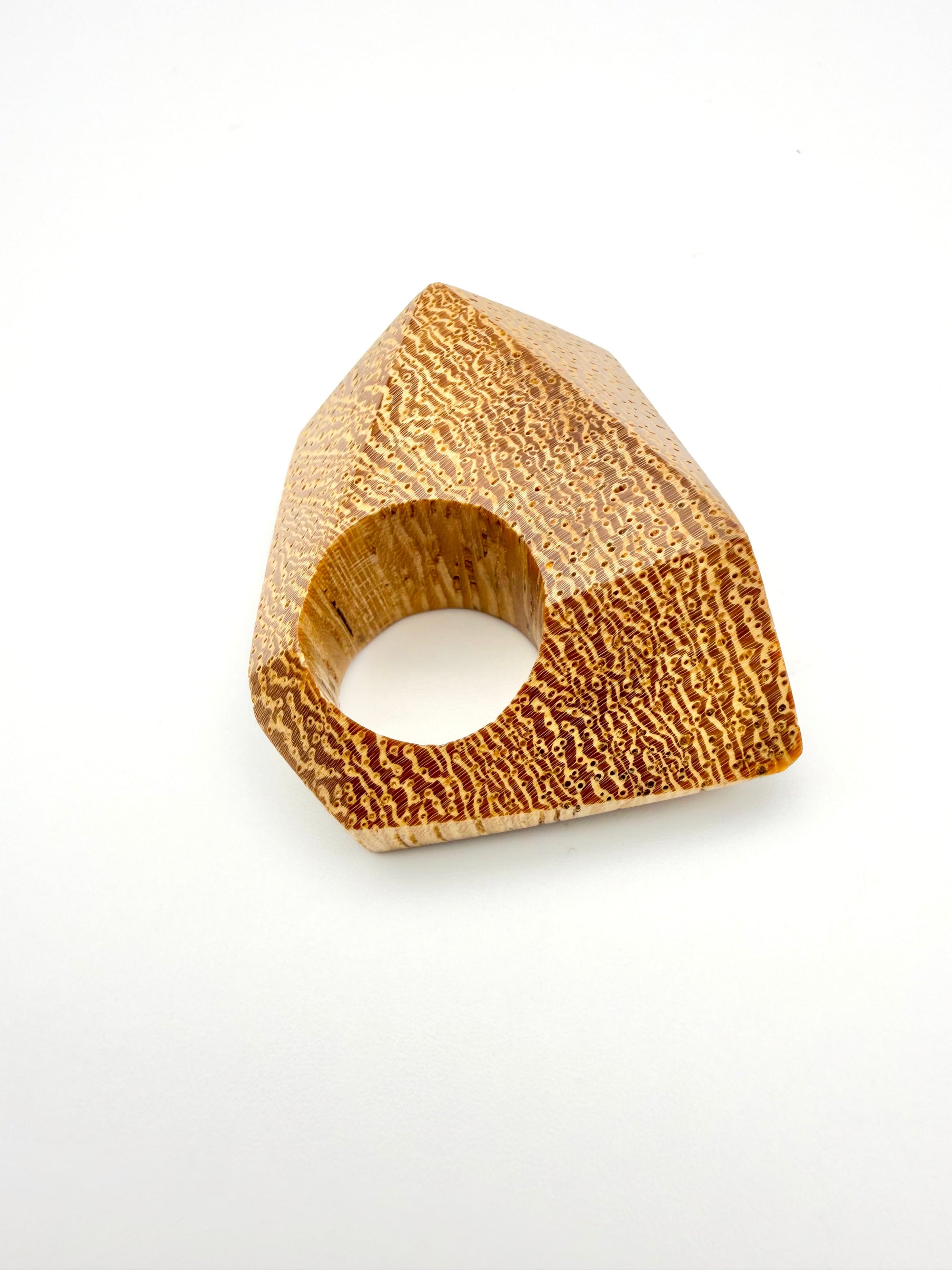 Wooden ring with a geometric design on a white background