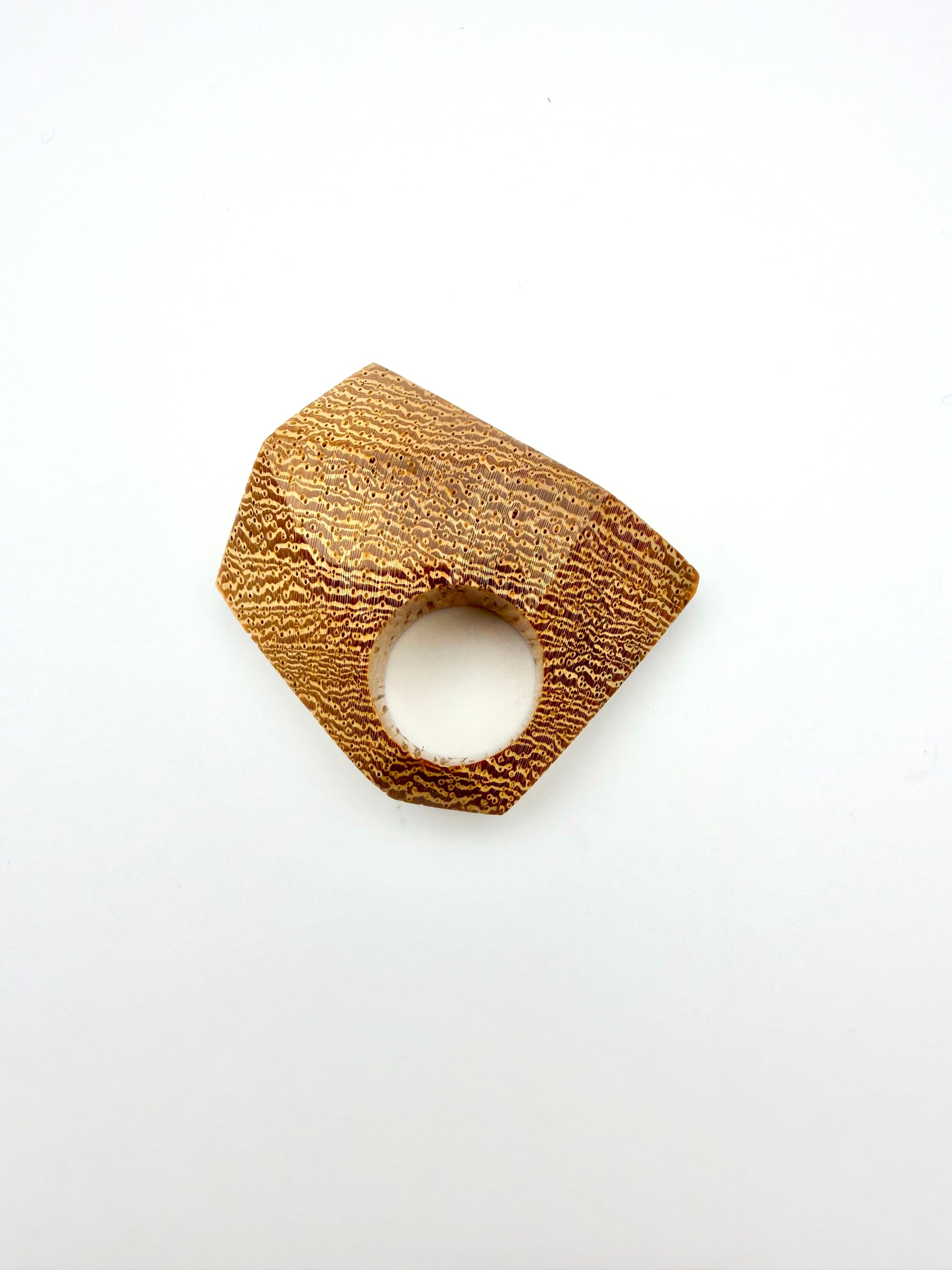Gold tone geometric wood ring on a white background