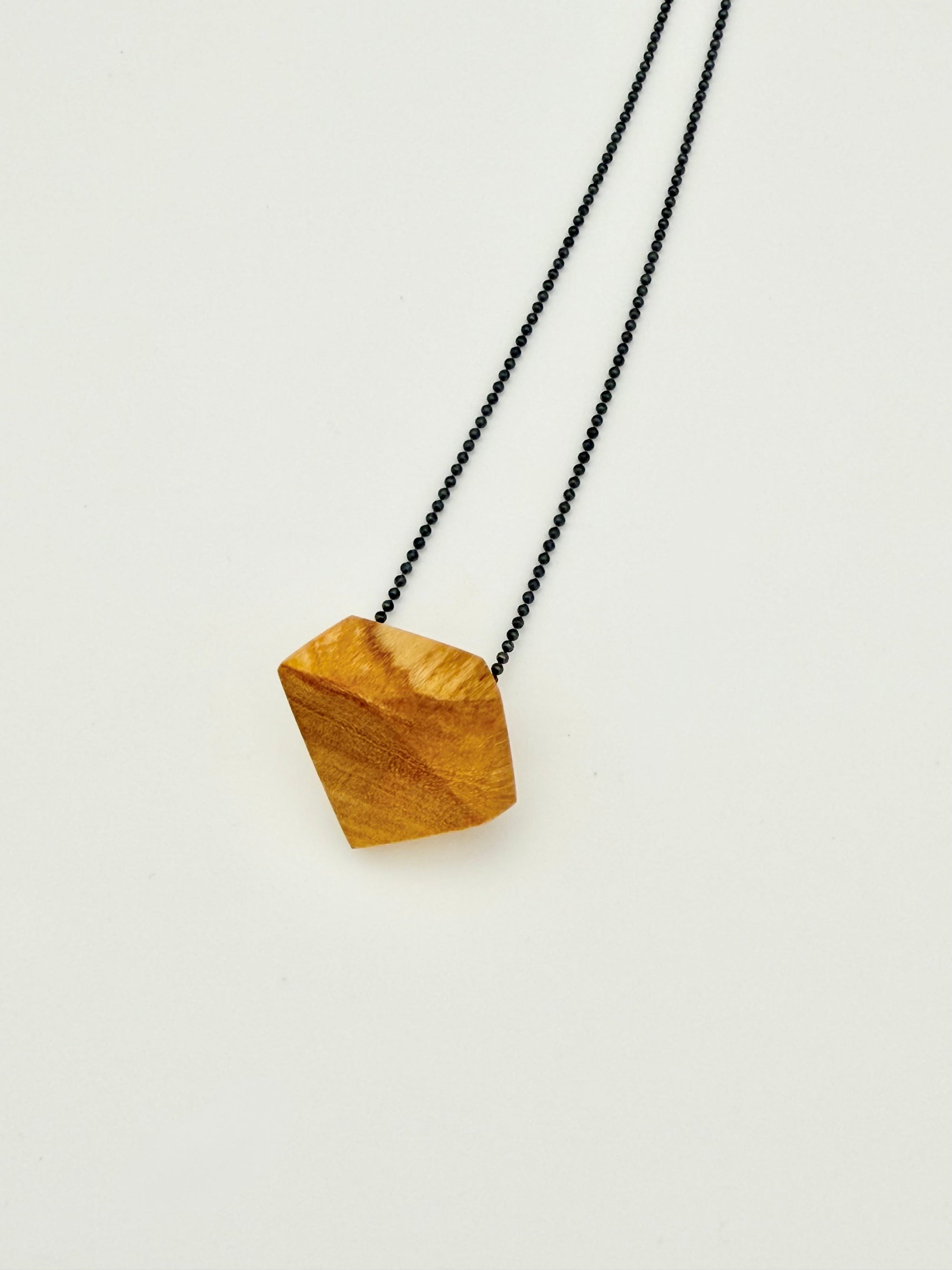 Olivewood geometric pendant necklace on an oxidized silver chain with white background