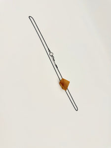 Geometric olivewood pendant on an oxidized silver chain with custom clasp on white background. 