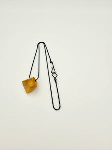 Geometric olivewood pendant on an oxidized silver chain with custom clasp on white background. 