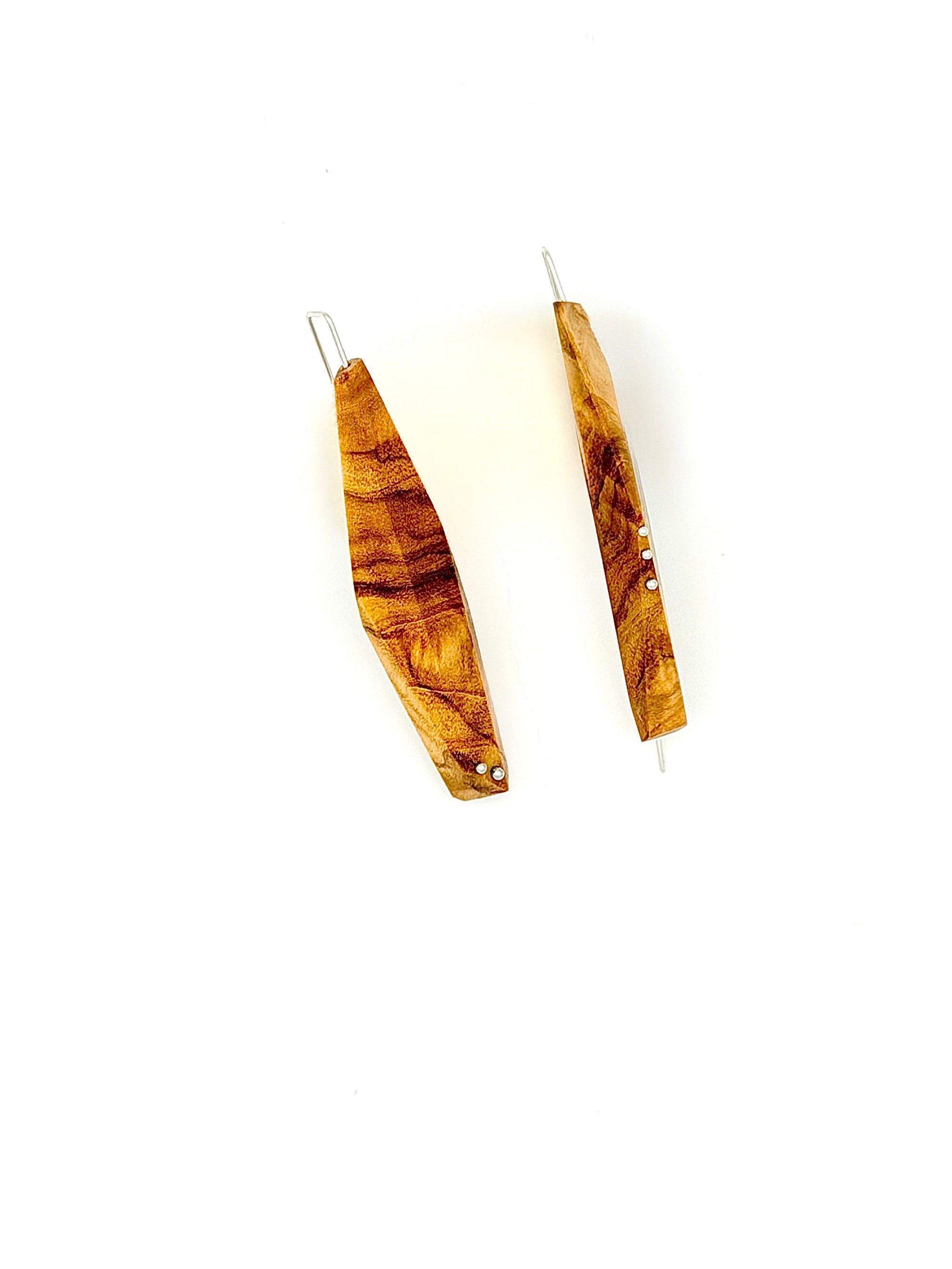 Olivewood asymmetric long narrow earrings with silver details on white background. 