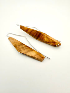 Olivewood asymmetric and geometric long narrow earrings with silver details on white background. 
