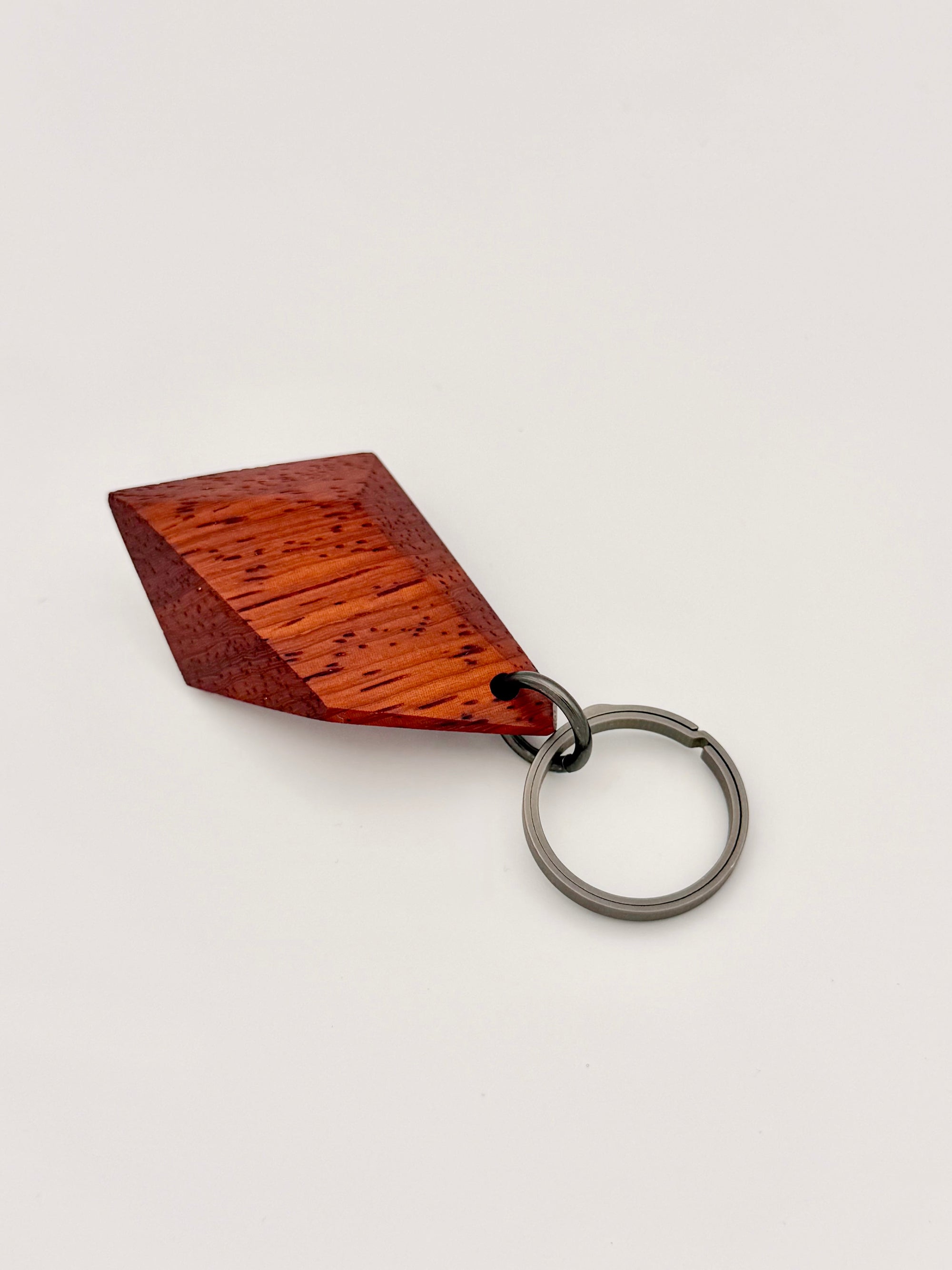 Orange Wood keychain with a titanium ring on a white background