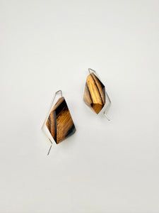 Pair of geometric earrings with wooden design on a white background