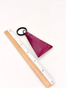 Wooden ruler with a purple triangle Keychain with a black ring on a white background
