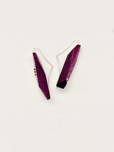 Pair of purple earrings on a white background