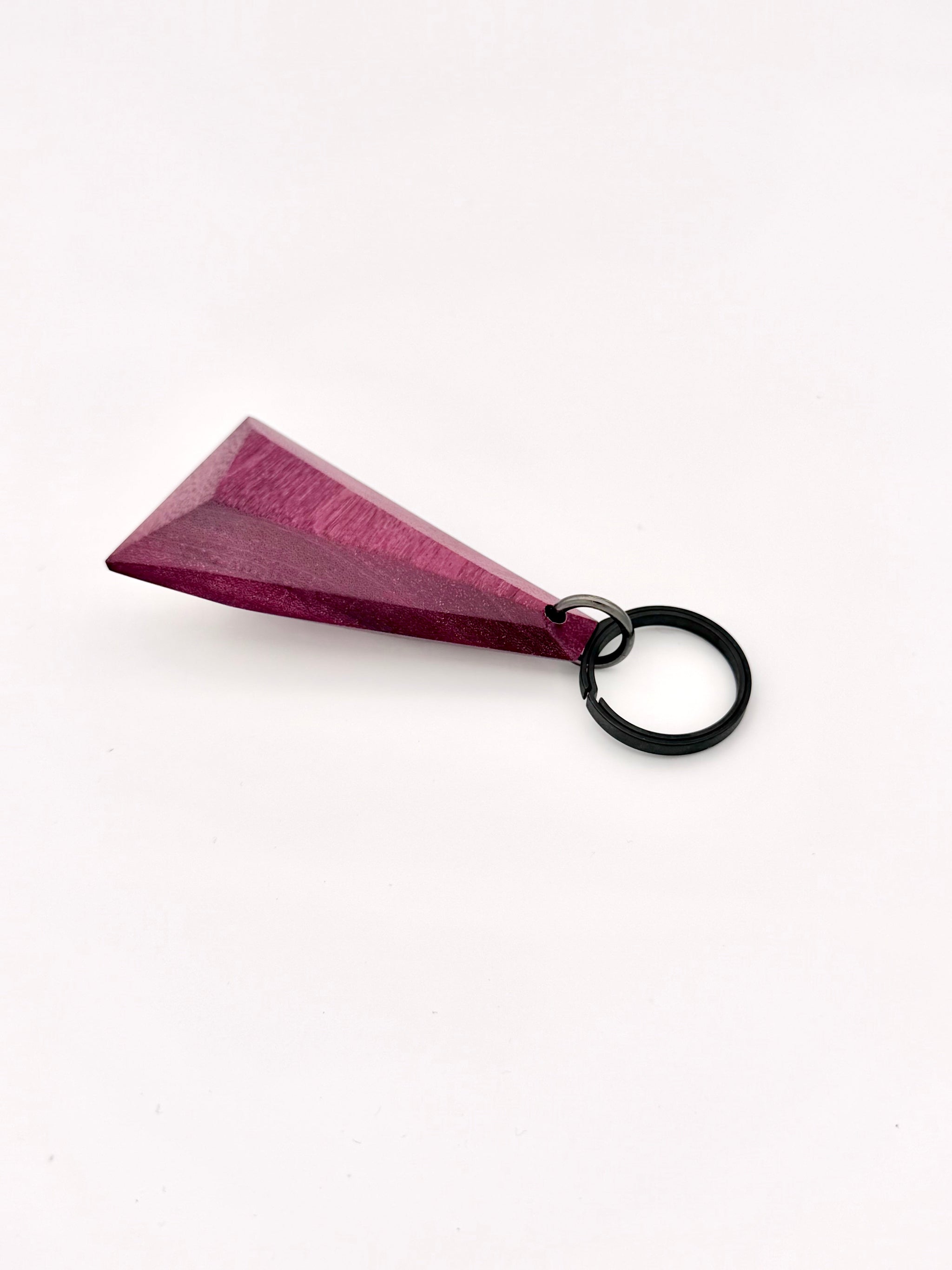 Triangular purple wood keychain on a white background with black titanium ring