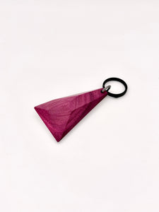 Faceted purple wood keychain with a black ring on a white background