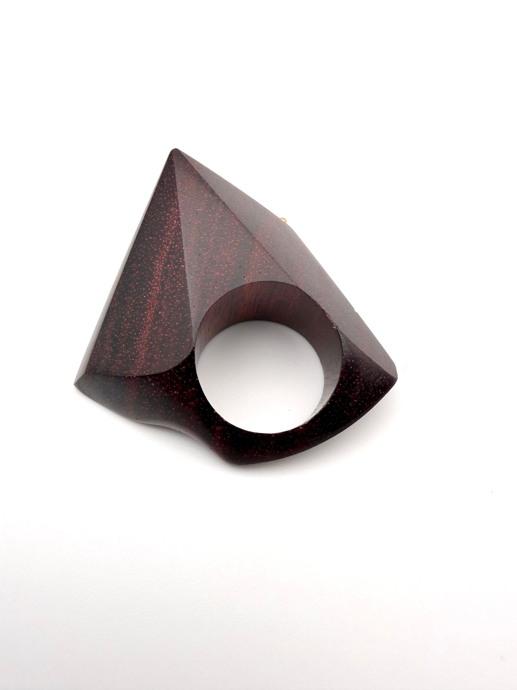 Burgundy geometric wood sculpture ring on a white background