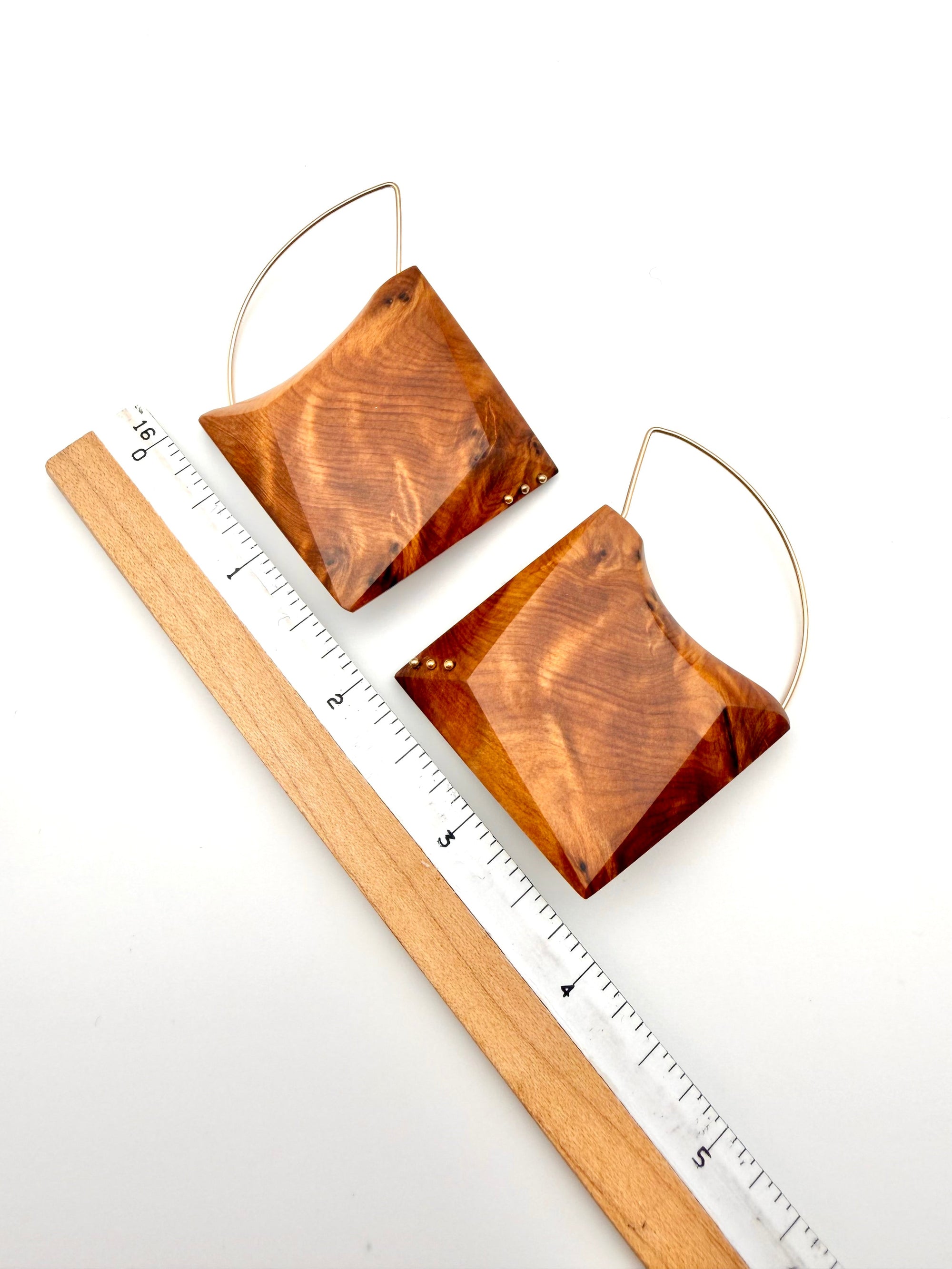 ornate wood grain geometric earrings with Gold Filled details and hoops next to ruler for scale on white background. 