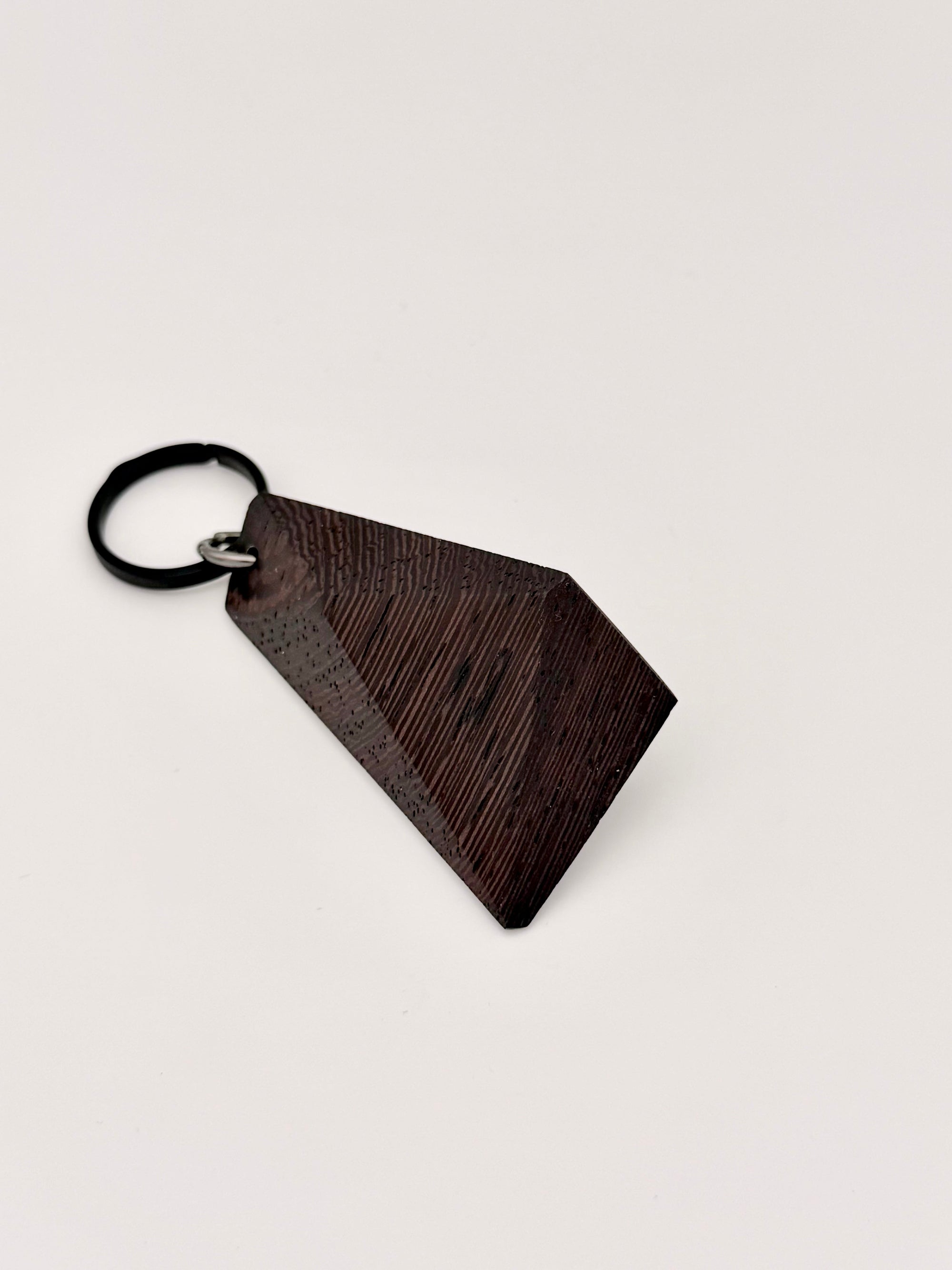 Wenge wood geometric keychain on a light gray background