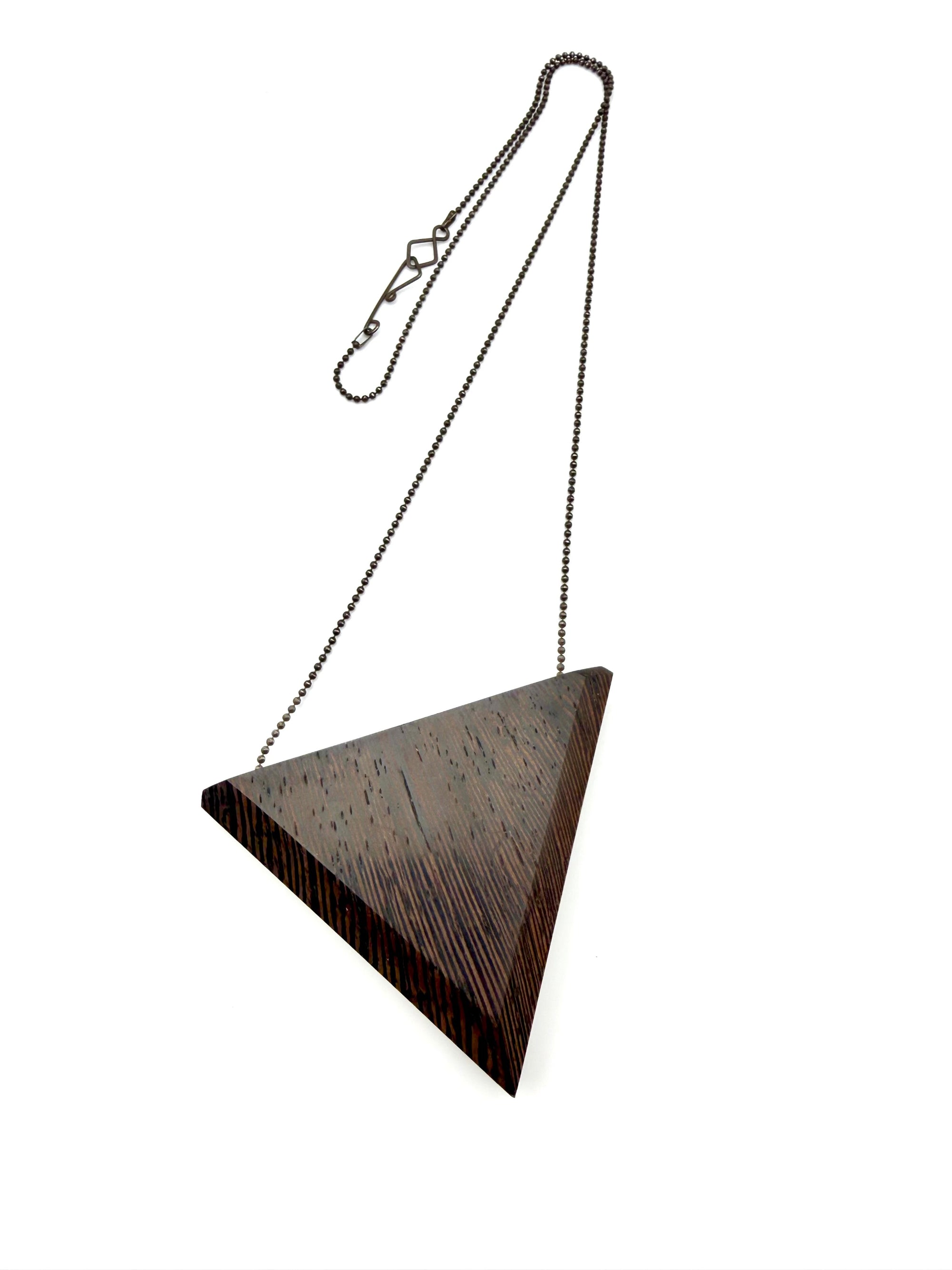 Dark wood triangular pendant with chain on a white background