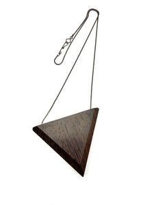 Dark wood triangular pendant with chain on a white background