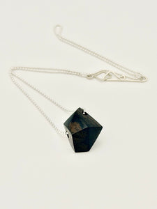 Necklace with a black geometric wood pendant on a silver ball chain displayed on a white background