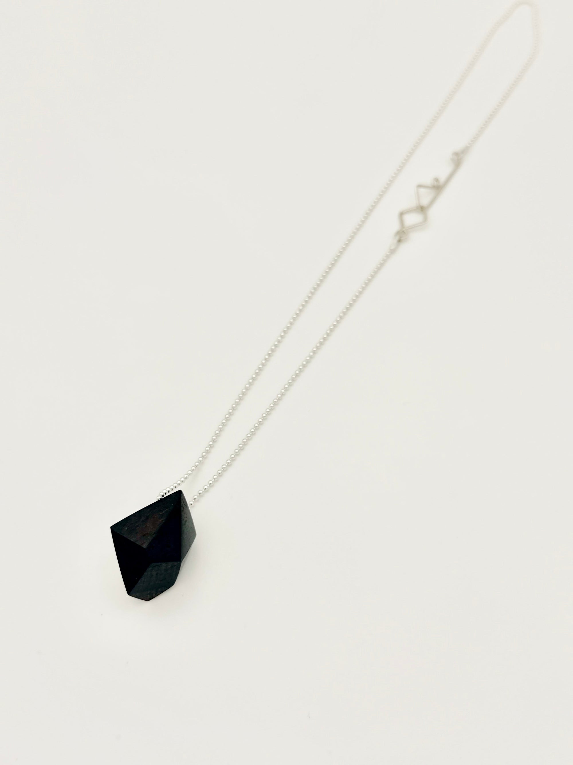 Necklace with a black pendant on a white background