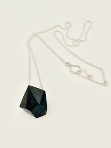 Necklace with a black wood geometric pendant on a silver bead chain with custom clasp displayed on a white background